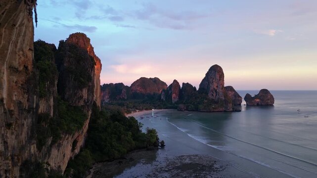 Krabi, Thailand: Aerial drone footage of the dramatic sunset over the limestone landscape of Railay, or Raliey beach in Krabi in Thailand by the Andaman sea. Shot with a rotation motion. 