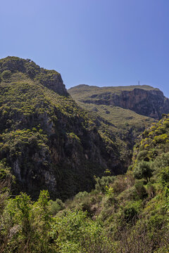 Scenic view of the lush, steep and tall mountains at the Topolia Gorge in Crete, Greece, on sunny day from above.