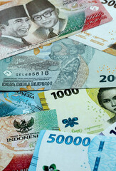 Indonesian rupiah money banknotes pile on table. Indonesia bills of IDR currency close up © Larysa