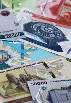 Uzbekistani som money banknotes pile on table. Uzbekistan bills of UZS currency close up