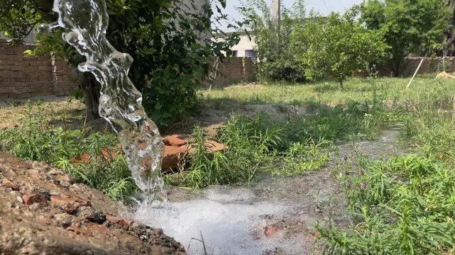 Electric water pump flowing into irrigation channel, Punjab, Pakistan