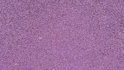 Fototapeta premium A high-angle, full-frame shot of a textured purple EPDM rubber crumb surface, commonly used for playground safety flooring or athletic tracks to provide impact absorption.