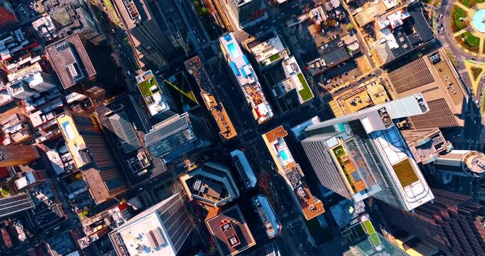 Flying over the tops of high-rises and skyscrapers in the modern city. Lively noisy streets of Philadelphia, Pennsylvania, USA. Top view.