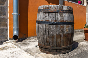 Fototapeta premium A stroll through the narrow streets of the old town of Motovun in Croatia, with a wine barrel and an old wooden brandy barrel displayed in front of the house. 