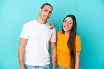 Fototapeta premium Young caucasian couple isolated on blue background happy and laughing