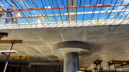 Fototapeta premium Construction workers build a massive concrete bridge