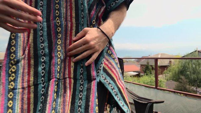 Creative Artistic Freelancer in Woven South American Poncho and Round Sunglasses Standing Up from Camping Chair on Wooden Veranda to Leave Scene against Coastal Harbor and Foggy Mountain Vista
