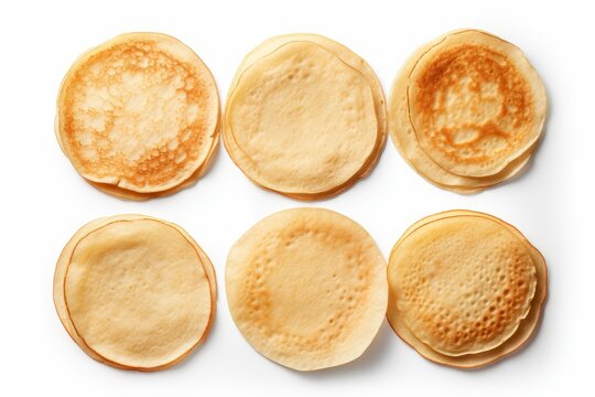 Six piles of thin, cooked pancakes on a white background