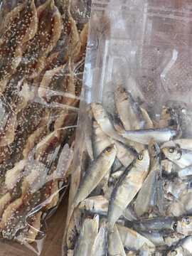 Dried fish packaged in clear plastic bags for sale at local market showcasing traditional seafood preservation methods yielding satisfying and appetizing display of culinary ingredients