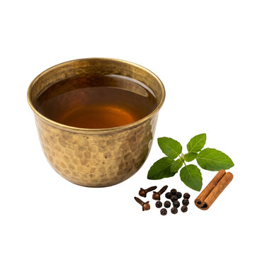 Traditional Ayurvedic Kadha herbal decoction in a brass cup
