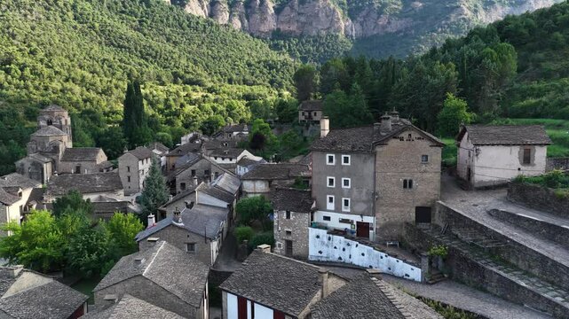 Aerial perspective of the traditional medieval stone houses and slate roofs of Rupit, a picturesque town nestled in a lush green valley
