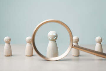 Fototapeta na wymiar Magnifying glass highlighting happy figure among sad figures, representing mental health awareness, emotional support, therapy, resilience and positive wellbeing.