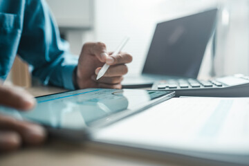 Fototapeta premium Professional using tablet and laptop for financial analysis dashboard, accounting reports and ERP data management, representing business planning, budgeting and digital analytics workflow.
