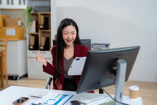 Overjoyed, Asian female businessman celebrates a financial bonus.