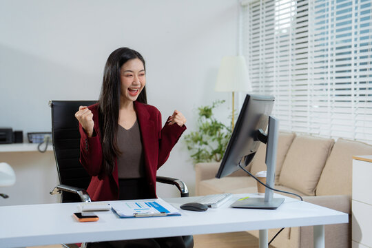 Overjoyed, Asian female businessman celebrates a financial bonus.