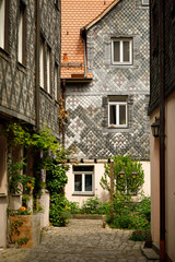 Obraz premium Colorful Historic House with Traditional Tile Facade on Narrow Old Town Street in Bavaria Germany - Medieval European Architecture