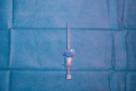 Single Blue Peripheral Intravenous (IV) Cannula on Sterile Surgical Drape - Medical Equipment and Nursing Care