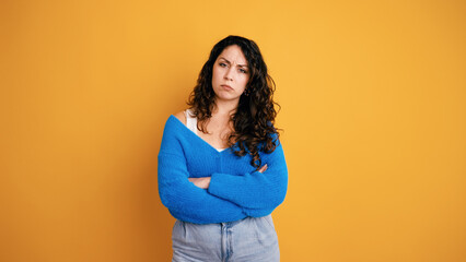 Obraz premium Woman standing with arms crossed, frowning her face, showing disappointment, annoyance, and being upset on an orange background