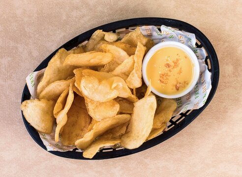 Crispy homemade potato chips served with creamy cheese dip