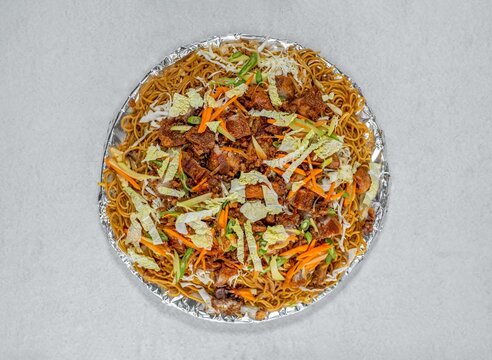 Large tray of pancit canton noodles with crispy bagnet pork and vegetables