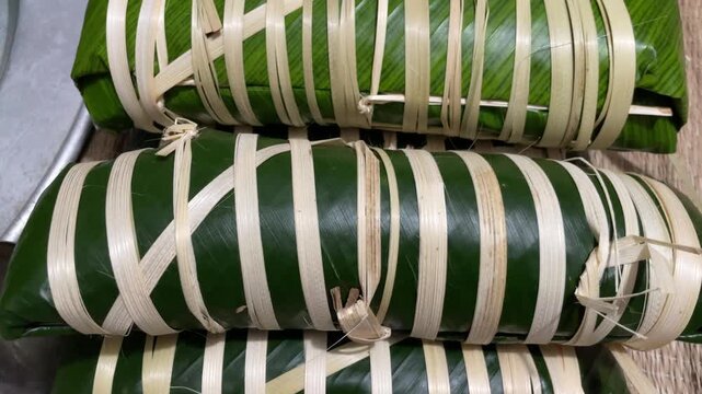 Rows of newly wrapped banh tet in Vietnam, ready to be boiled for Lunar New Year, captured for festive food preparation and cultural tradition footage.