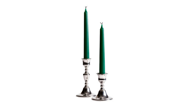 Two tall green taper candles in ornate silver candlesticks, isolated on transparent background