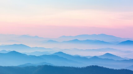 Obraz premium Mountain sunrise landscape with rugged ridges, soft dawn haze and warm morning sunlight