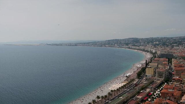 Panoramic aerial view of nice, france: pebble beach, promenade des anglais and urban coastline meeting the calm blue mediterranean, iconic riviera cityscape perfect for travel