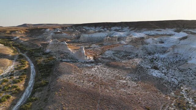 Drone view of bizarre white chalk outcrops from the ancient Tethys Ocean. Unique geological formations and rock shapes in the Mangystau desert. Footage showcases the incredible relief and textures
