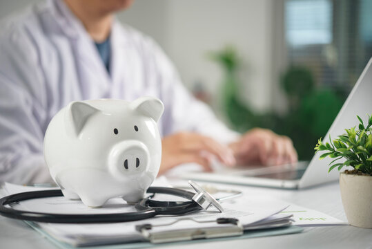Piggy bank and stethoscope on doctor desk for medical savings and health insurance