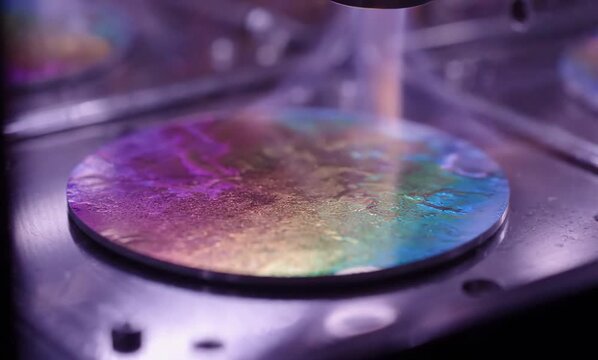 Iridescent metallic film forms gradually across silicon surface beneath glowing plasma laboratory illumination beautifully