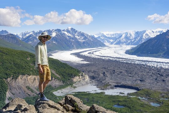 Young man enjoying the view, view of impressive mountain landscape with Matanuska glacier and glaciated mountain peaks, Lion's Head, Chugach Mountains, Alaska, USA