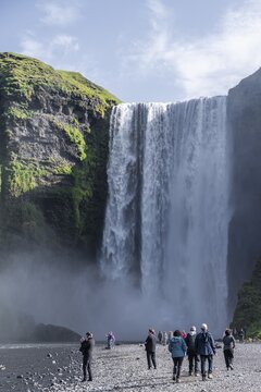 Sk&oacute;gafoss waterfall in summer when the weather is fine, tourists next to waterfall in a gorge, Skogar, Sudurland, South Iceland, Iceland