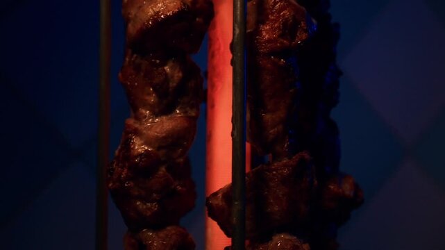 Close up slowmo video of pork pieces cooking on electric barbecue grill in kitchen with detailed food preparation in FHD 96 fps