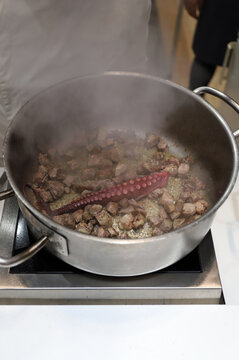 guiso de carne con pulpo en una olla coci&eacute;ndose en la cocina