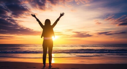 Fototapeta premium Silhouette of a Person with Arms Raised in Triumph at Sunset on a Beach.