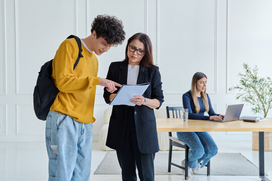 Female teacher and male university student together inside the classroom