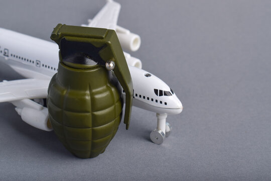 Passenger airplane beside hand grenade representing aviation terrorism, airport security threats, dangerous baggage, flight safety risks, war conflict, and global transportation danger concept.