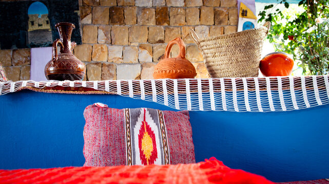 Handmade Moroccan cushions against a stone wall, highlighting textures and a warm traditional atmosphere.