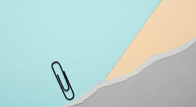 A black paperclip rests on a torn paper background with pastel blue, peach, and gray sections.