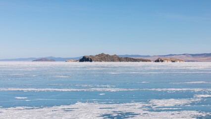 Wide winter view of frozen Lake Baikal with drifting ice floes and rocky islands on the horizon, Maloye More strait, Irkutsk Oblast, Russia © TravelFlow