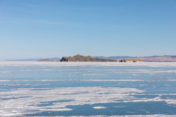 Wide winter landscape of frozen Lake Baikal with drifting ice floes and distant Olkhon Island on the horizon, Maloye More strait, Irkutsk Oblast, Russia © TravelFlow