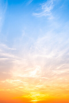 Sky sunset,Beautiful sunrise sky with vibrant gradient orange and gold colors and soft blue, Clear atmosphere with wispy clouds. Peaceful, perfect for background and copy space, vertical