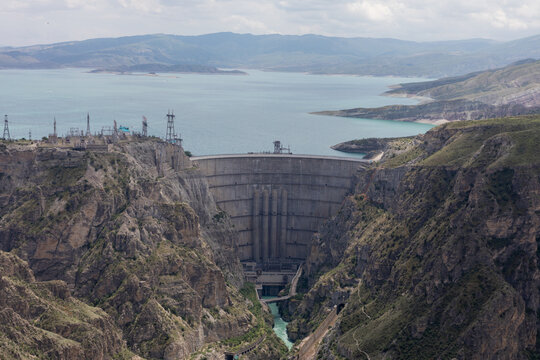 Wide panoramic view from a lookout over the Chirkey Hydroelectric Power Station dam and turquoise reservoir in the mountains near Dubki, Dagestan, Russia