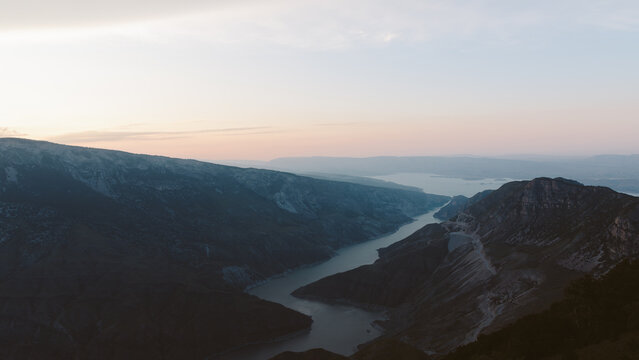 Wide panoramic landscape of the Main Sulak Canyon with winding river between steep rocky mountains at sunrise, Dagestan, Russia, tranquil travel destination