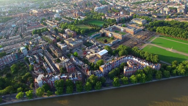 4K aerial view of Cheyne Walk and Chelsea Embankment riverside with Queen Anne mansions, Chelsea Physic Garden, Royal Hospital Chelsea and River Thames at golden hour summer evening.
