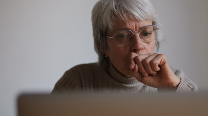 Fototapeta premium Senior Woman Thinking At Laptop At Home