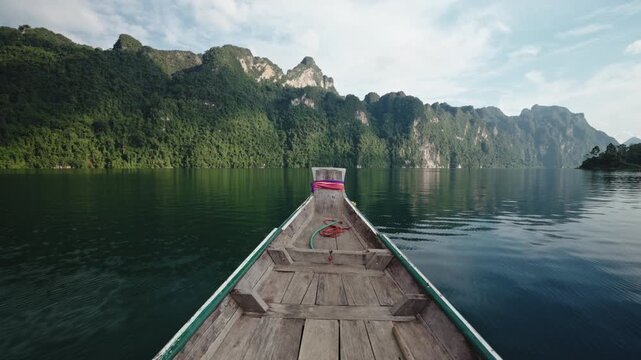 Cinematic Fast Motion of Traditional Longtail Boat Gliding Rapidly Across Emerald Waters of Cheow Lan Lake, Majestic Limestone Cliffs and Rainforest Landscape, Khao Sok