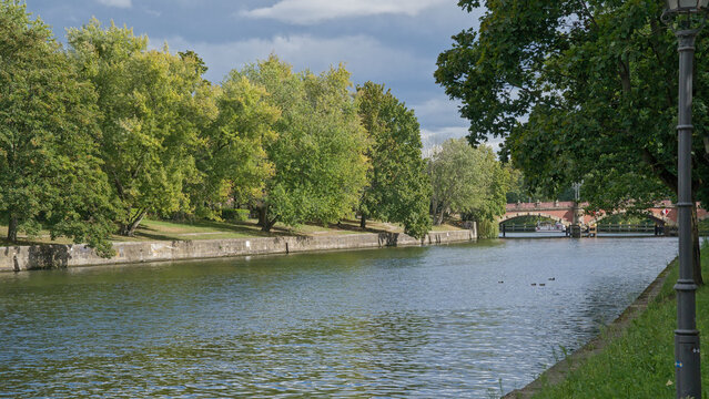 River Spree with Luther historical brick arch bridge and green trees on the borders in Berlin, Germany 