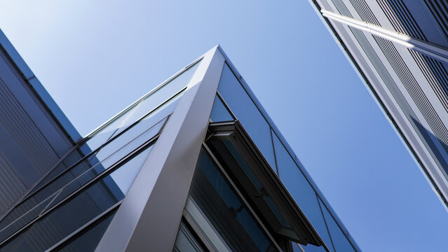 Angular Modern Architecture with Reflective Glass Windows and Striped Facade Against a Clear Blue Sky